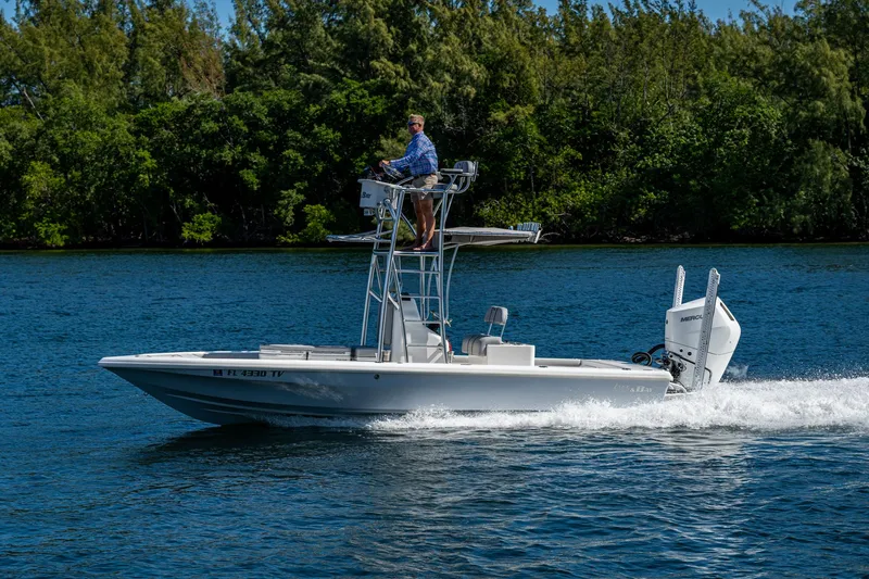 Slide: The Image of 2023 Lake & Bay Backwater boat cruising on a scenic lake with lush greenery. - 11