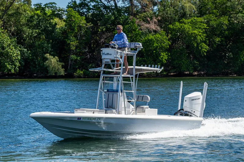 Slide: The Image of 2023 Lake & Bay Backwater boat cruising on a scenic river with lush greenery. - 12