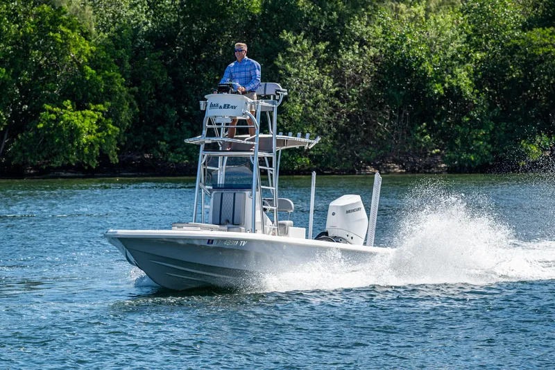 Slide: The Image of 2023 Lake & Bay Backwater boat cruising on a scenic waterway with lush greenery. - 13