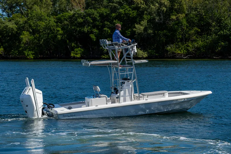 Slide: The Image of 2023 Lake & Bay Backwater boat cruising on a serene lake with lush greenery. - 16