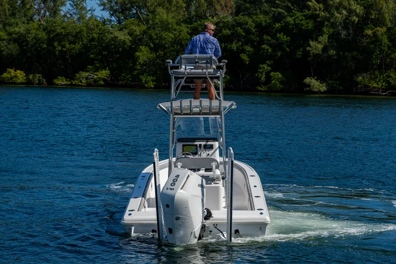 Slide: The Image of 2023 Lake & Bay Backwater boat cruising on a serene lake with lush greenery. - 19