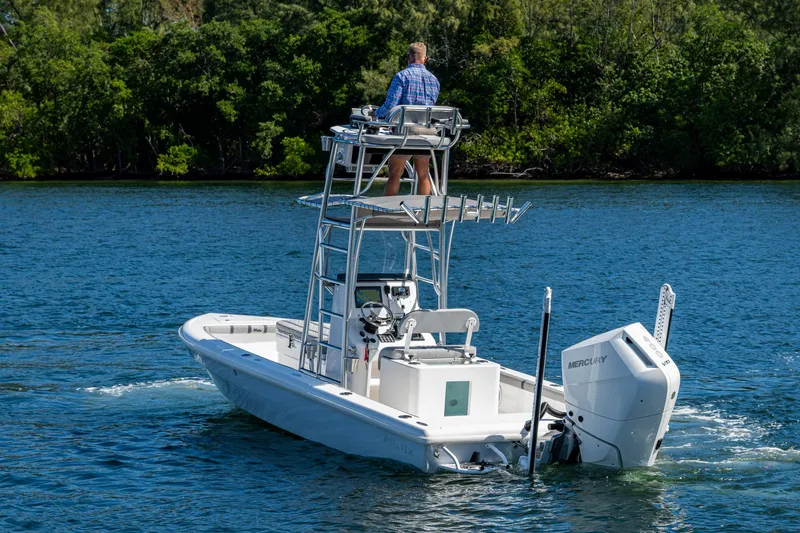 Slide: The Image of 2023 Lake & Bay Backwater boat cruising on a scenic lake with lush greenery. - 20