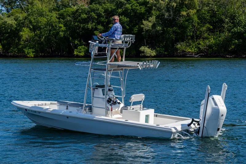 Slide: The Image of 2023 Lake & Bay Backwater boat on a serene lake with lush greenery. - 22