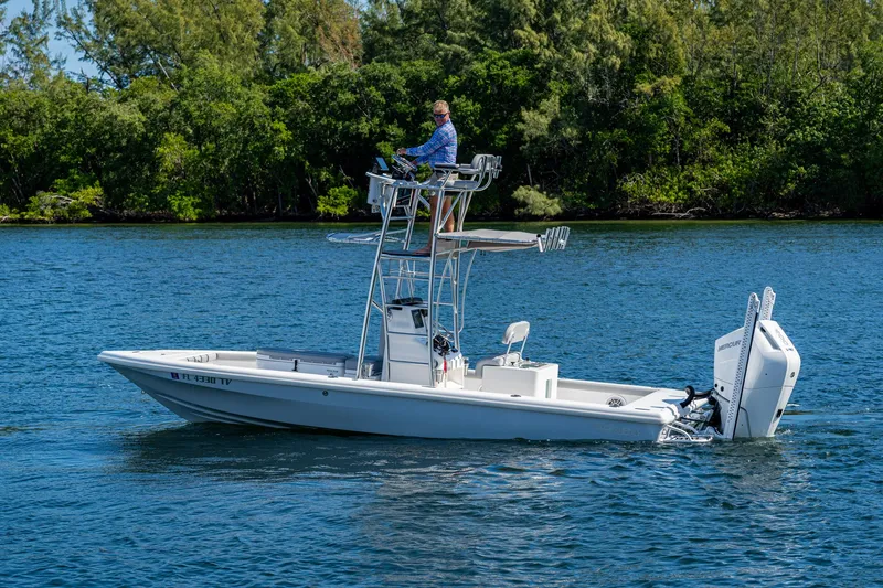 Slide: The Image of 2023 Lake & Bay Backwater boat on a calm lake with lush greenery. - 23