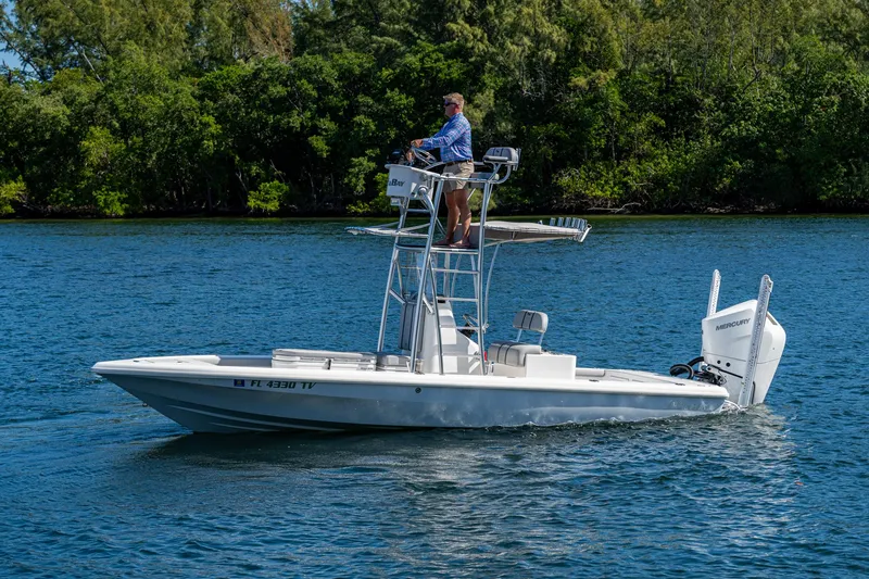 Slide: The Image of 2023 Lake & Bay Backwater boat cruising on a serene lake with lush greenery. - 25