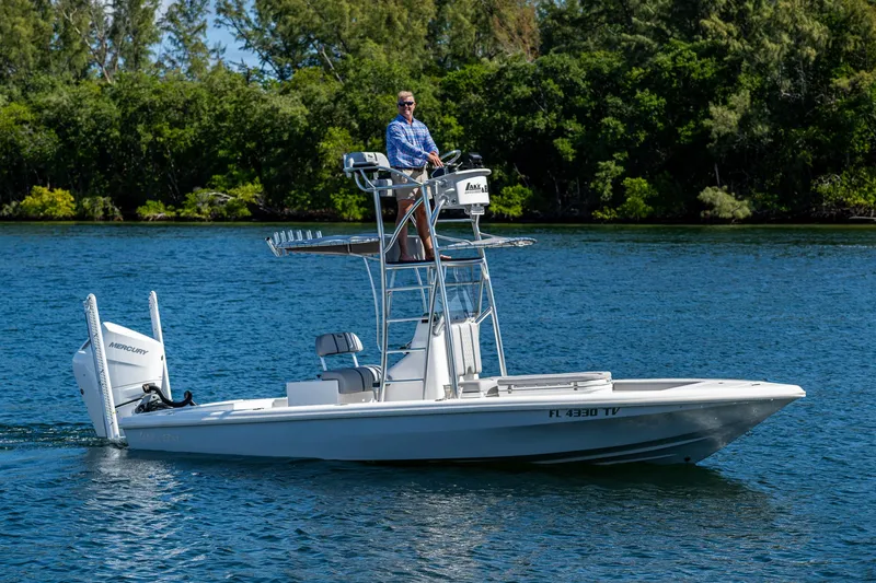 Slide: The Image of 2023 Lake & Bay Backwater boat on a serene lake with lush greenery in the background. - 32