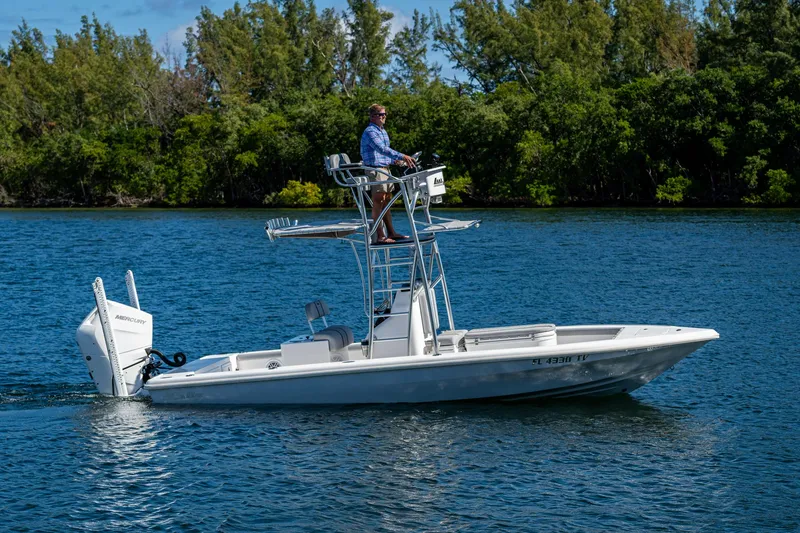 Slide: The Image of 2023 Lake & Bay Backwater boat cruising on a serene lake with lush greenery. - 33