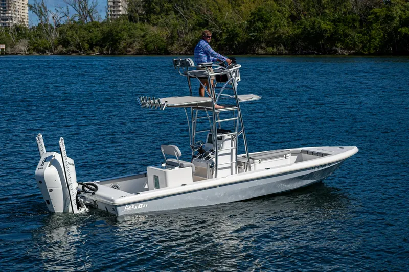 Slide: The Image of 2023 Lake & Bay Backwater boat on a calm lake with a person on the tower. - 36