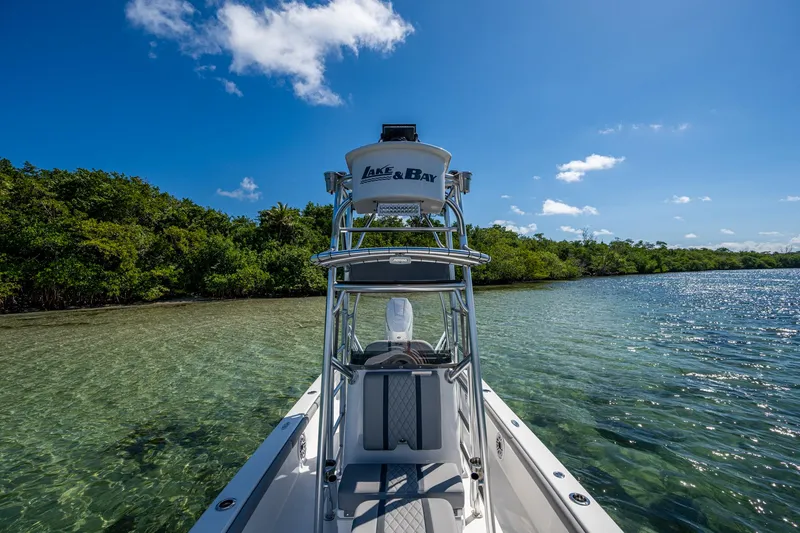 Slide: The Image of 2023 Lake & Bay Backwater boat on clear water near lush shoreline under blue sky. - 37