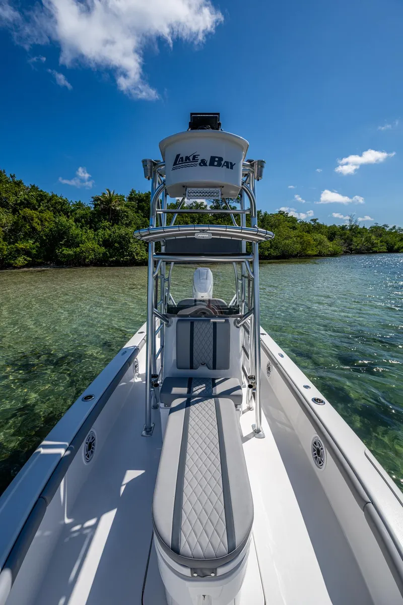 Slide: The Image of 2023 Lake & Bay Backwater boat on clear water, surrounded by lush greenery under a blue sky. - 38