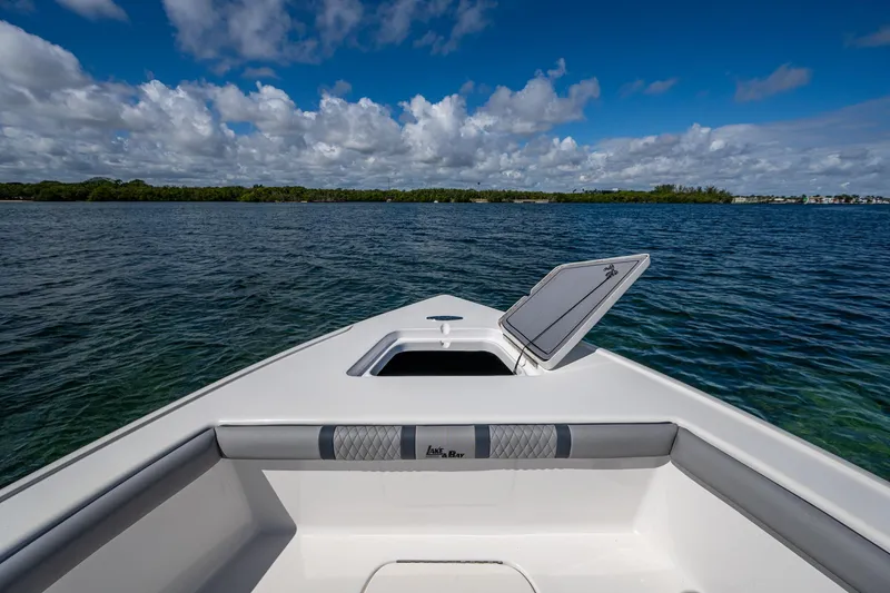 Slide: The Image of 2023 Lake & Bay Backwater boat on clear blue water under a partly cloudy sky. - 4