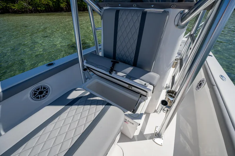 Slide: The Image of 2023 Lake & Bay Backwater boat interior with cushioned seating and storage, on clear water. - 44