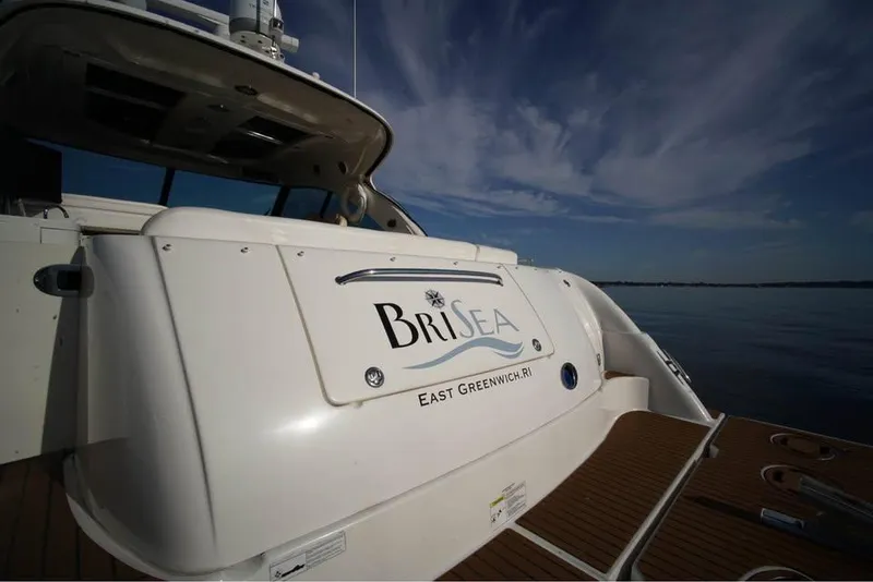 Slide: The Image of 2012 Sea Ray 500 Sundancer yacht with "BriSea" name, docked under a clear sky. - 4