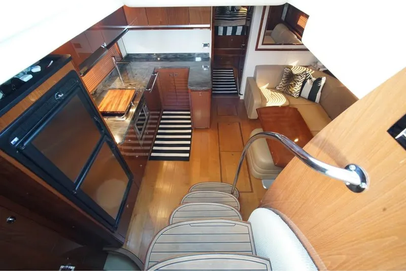 Slide: The Image of Interior of 2012 Sea Ray 500 Sundancer yacht, featuring kitchen and seating area. - 6