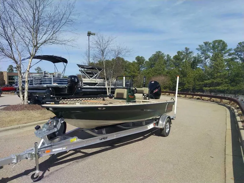 Slide: The Image of 2025 Mako 18 Pro Skiff Backwater Edition on trailer, parked outdoors. - 2
