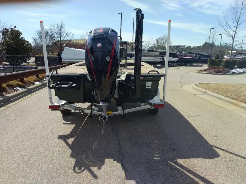 Slide: The Image of 2025 Mako 18 Pro Skiff Backwater Edition boat, rear view with motor, parked outdoors. - 5