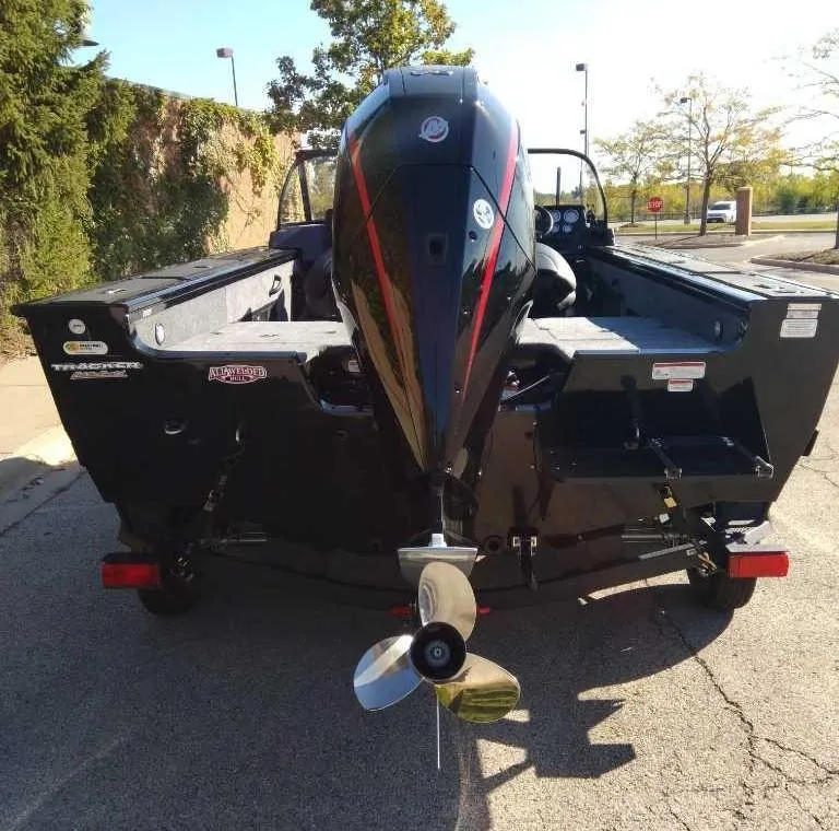 Slide: The Image of 2025 Tracker Targa V-18 WT boat, rear view with outboard motor, parked outdoors. - 3
