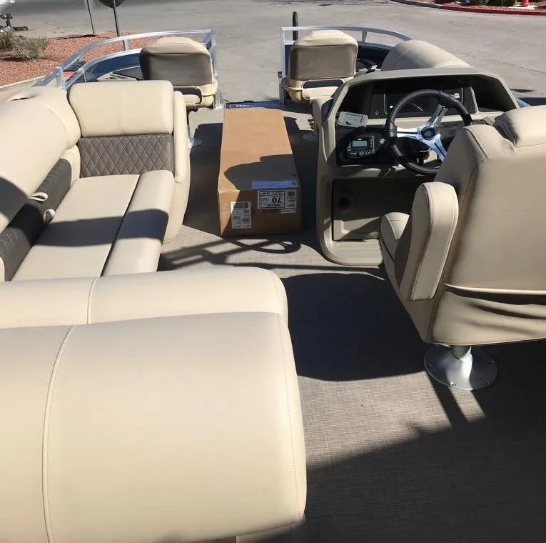 Slide: The Image of 2025 Sun Tracker Fishin' Barge 20 DLX interior with beige seating and steering console. - 5