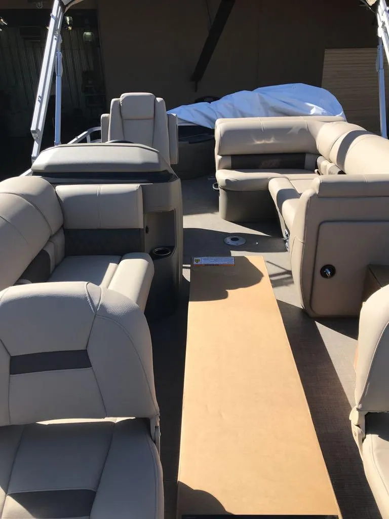 Slide: The Image of 2025 Sun Tracker Fishin' Barge 20 DLX interior with beige seating and spacious layout. - 6