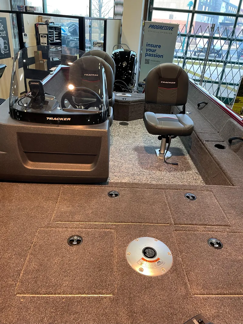 Slide: The Image of 2025 Tracker Pro Guide V-16 SC fishing boat interior with seating and control console. - 2