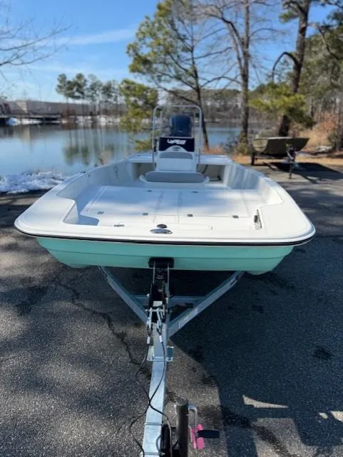 Slide: The Image of 2025 Mako Pro Skiff 17 CC boat on trailer by a lake. - 45