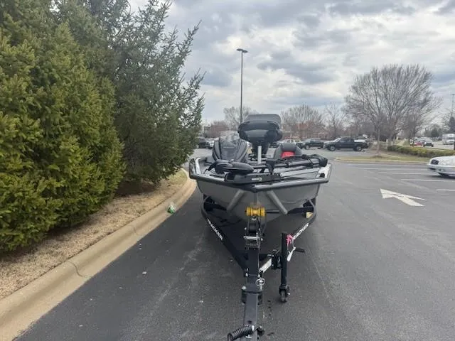 Slide: The Image of 2025 Tracker Pro Team 190 boat on trailer in parking lot, overcast sky. - 2