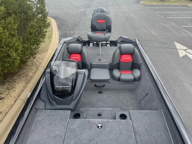 Slide: The Image of 2025 Tracker Pro Team 190 boat with gray and red seating, parked on asphalt. - 5