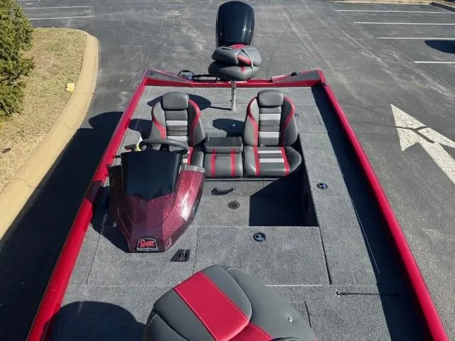 Slide: The Image of 2025 Ranger RT178C fishing boat with red and gray seating, parked on asphalt. - 3