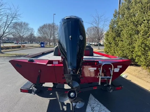 Slide: The Image of 2025 Ranger RT178C boat, red exterior, parked outdoors with outboard motor visible. - 4