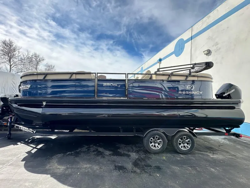The Image of 2025 Regency 230 DL3 pontoon boat with sleek design on a trailer. - 0