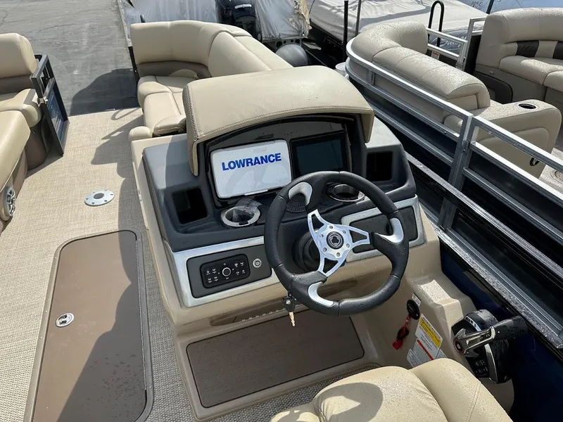 Slide: The Image of 2025 Regency 230 DL3 boat dashboard with Lowrance navigation system and comfortable seating. - 10