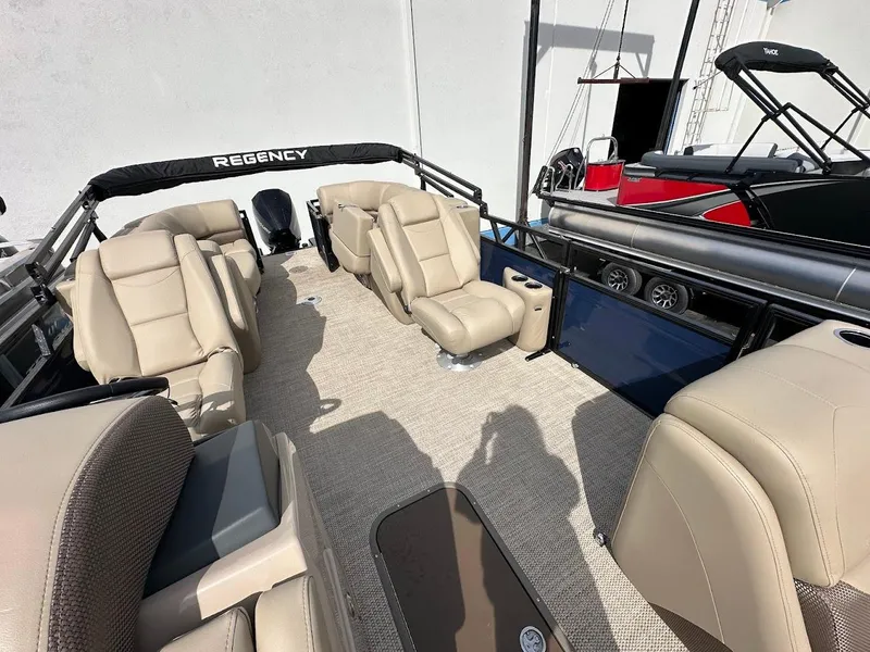 Slide: The Image of 2025 Regency 230 DL3 pontoon boat with beige seating and spacious deck layout. - 7