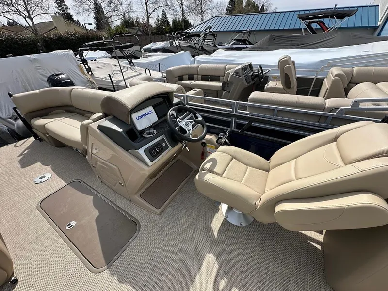 Slide: The Image of 2025 Regency 230 DL3 pontoon boat interior with beige seating and modern dashboard. - 9