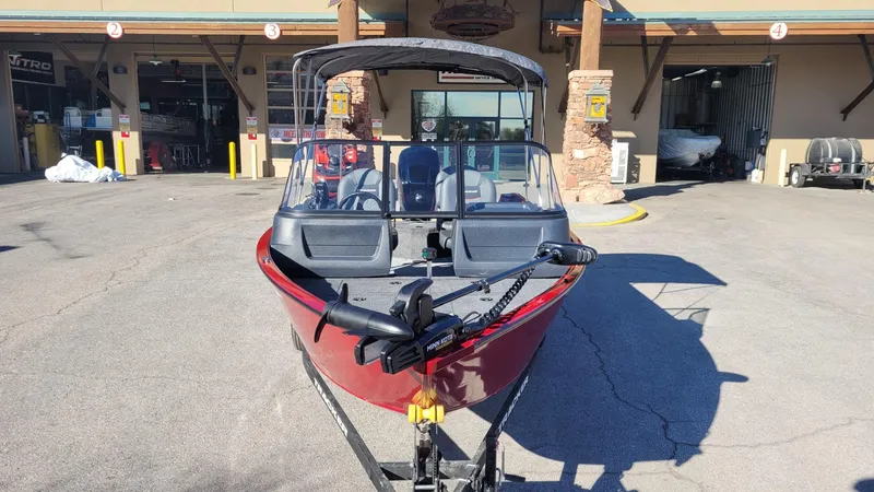 Slide: The Image of 2025 Tracker Pro Guide V-16 WT boat parked outside a building. - 2