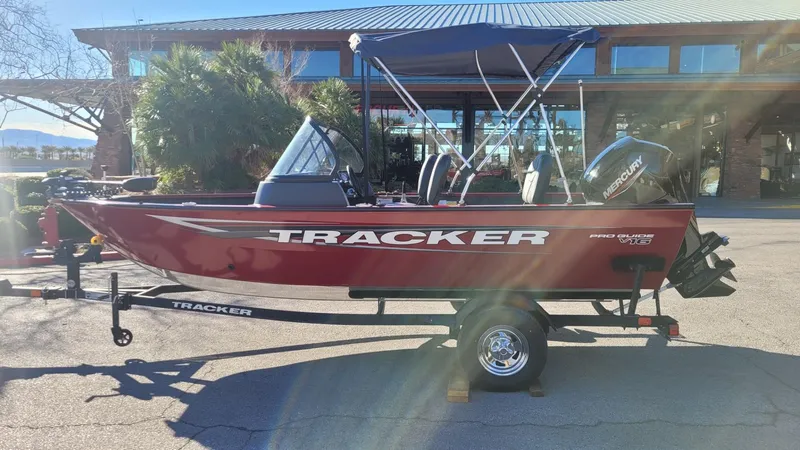 Slide: The Image of 2025 Tracker Pro Guide V-16 WT boat, red, on trailer, parked outdoors. - 4