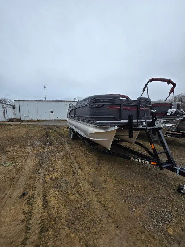 Slide: The Image of 2025 Qwest Splash Pad M-Class boat on trailer, parked outdoors. - 11