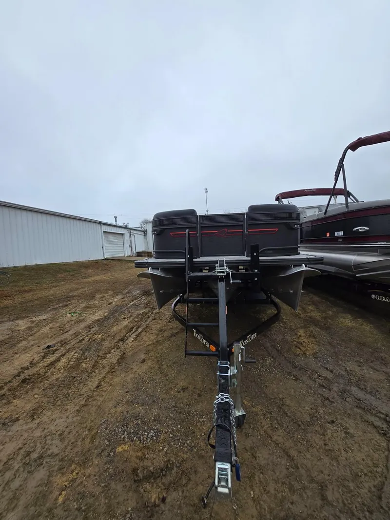 Slide: The Image of 2025 Qwest Splash Pad M-Class boat on trailer, parked outdoors on a cloudy day. - 14