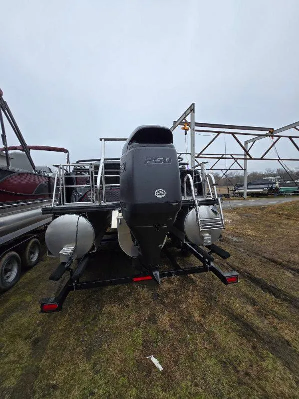 Slide: The Image of 2025 Qwest Splash Pad M-Class pontoon boat on trailer, rear view with motor. - 7