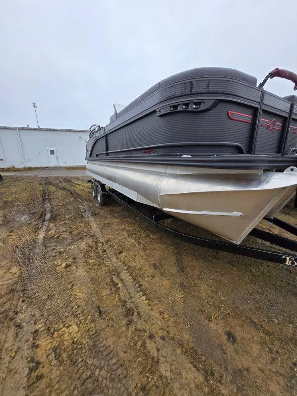 Slide: The Image of 2025 Qwest Splash Pad M-Class boat on trailer, parked on muddy ground. - 8