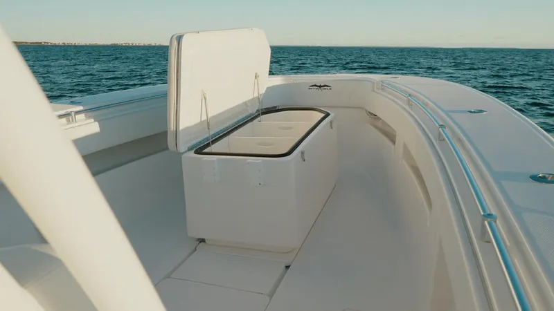 Slide: The Image of 2020 Invincible 36 CC boat interior with open storage compartment on calm sea. - 13
