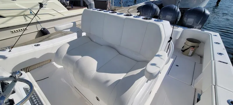 Slide: The Image of 2020 Invincible 36 CC boat interior with white seating and triple outboard engines. - 6