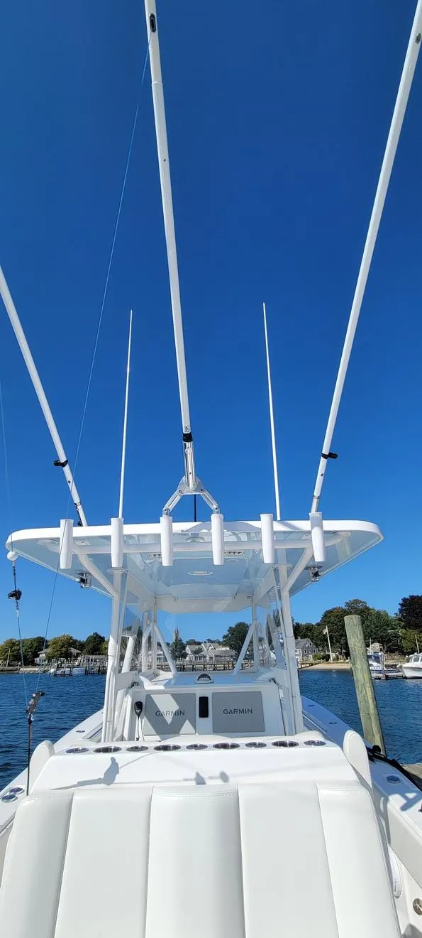 Slide: The Image of 2020 Invincible 36 CC boat with fishing rods, clear blue sky background. - 7