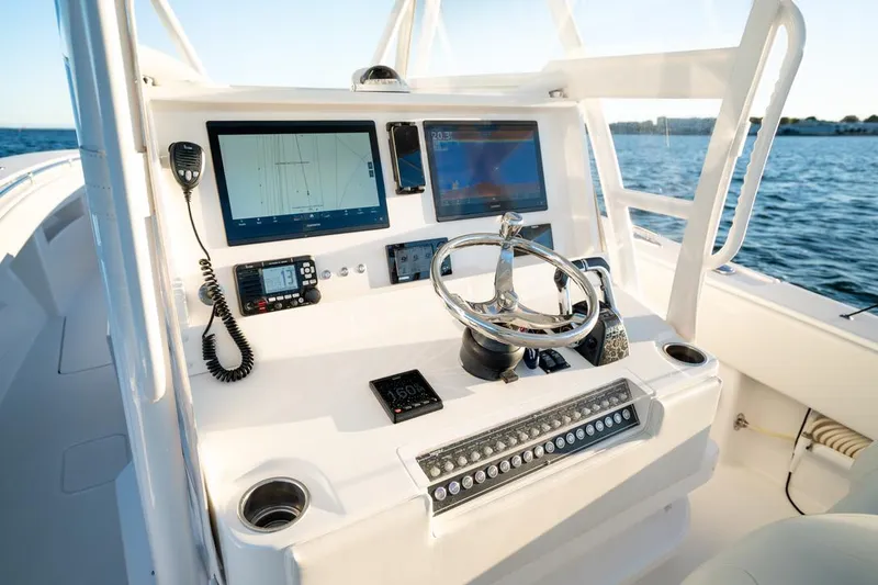 Slide: The Image of Invincible 36 CC 2020 boat dashboard with modern navigation equipment and steering wheel. - 9