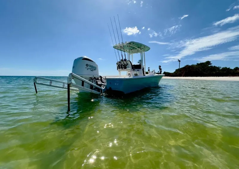 Slide: The Image of 2020 Tidewater 2300 Carolina Bay boat anchored in clear, shallow water near a sandy beach. - 2