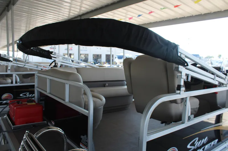 Slide: The Image of 2025 Sun Tracker Party Barge 16 DLX interior with seating and canopy under shelter. - 3
