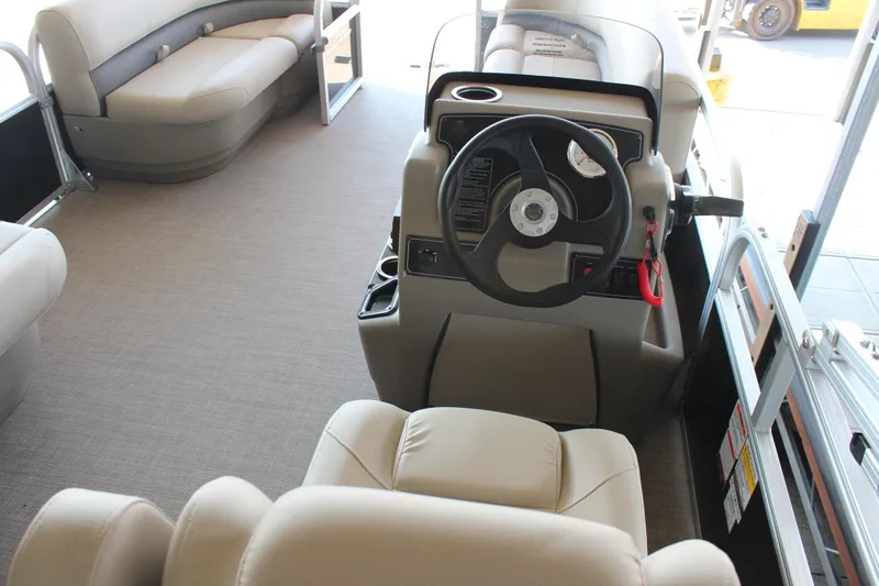 Slide: The Image of Interior of 2025 Sun Tracker Party Barge 16 DLX with beige seating and steering console. - 4