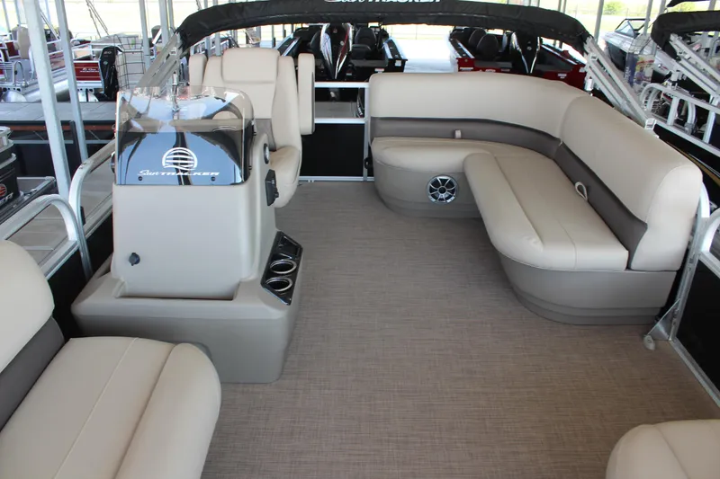 Slide: The Image of 2025 Sun Tracker Party Barge 16 DLX interior with beige seating and helm. - 8