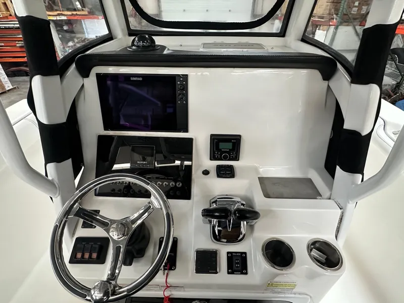 Slide: The Image of 2020 Sea Pro 259 Center Console boat dashboard with steering wheel and navigation controls. - 12