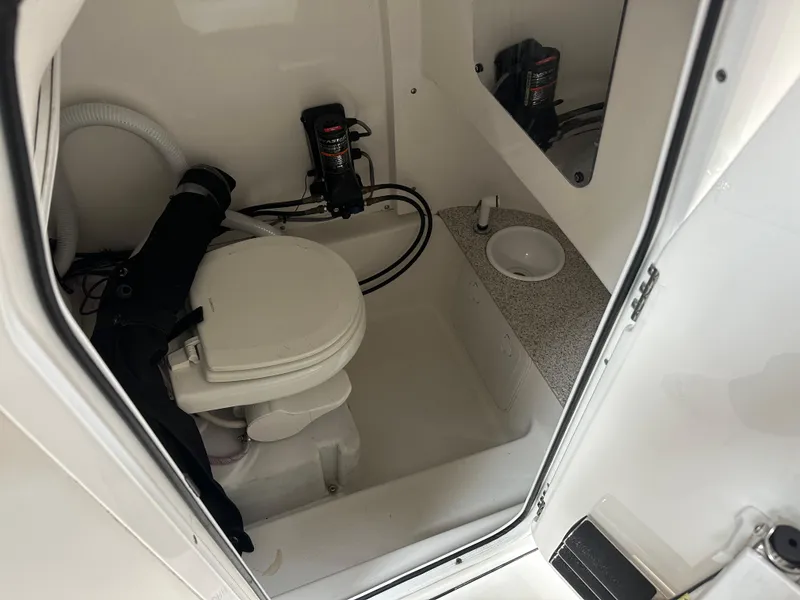 Slide: The Image of 2020 Sea Pro 259 Center Console boat bathroom with toilet and storage area. - 13