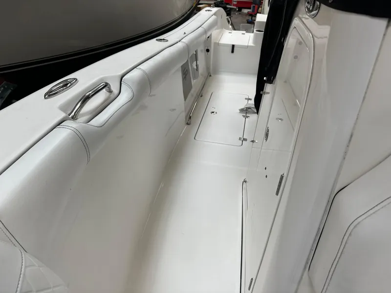 Slide: The Image of 2020 Sea Pro 259 Center Console boat interior, featuring sleek white seating and storage compartments. - 16